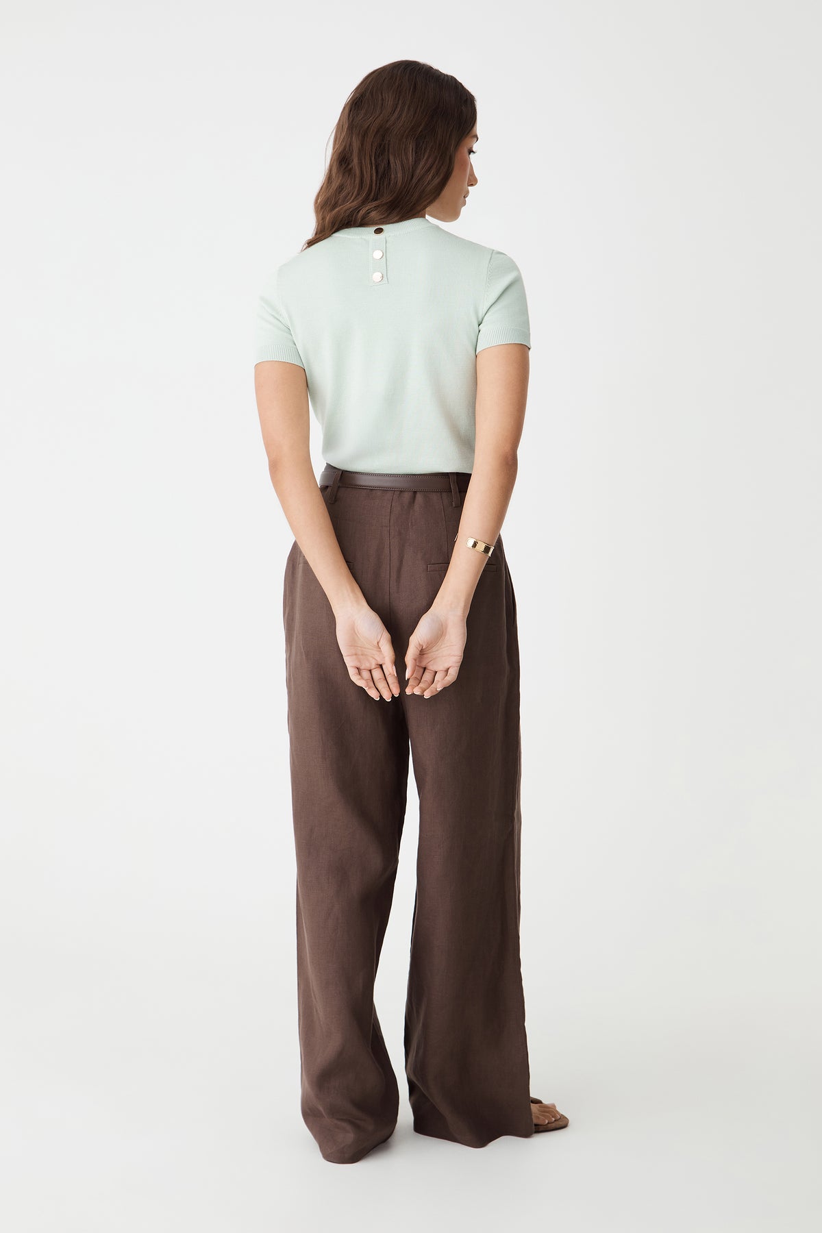 Back view showing the jade knit top with gold-tone button at the back neck