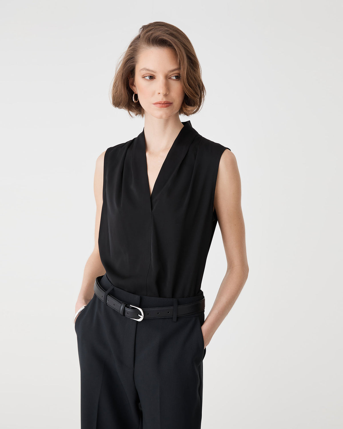Three-quarter close-up of the black Alivia 2 V-Neck Top with belted trousers