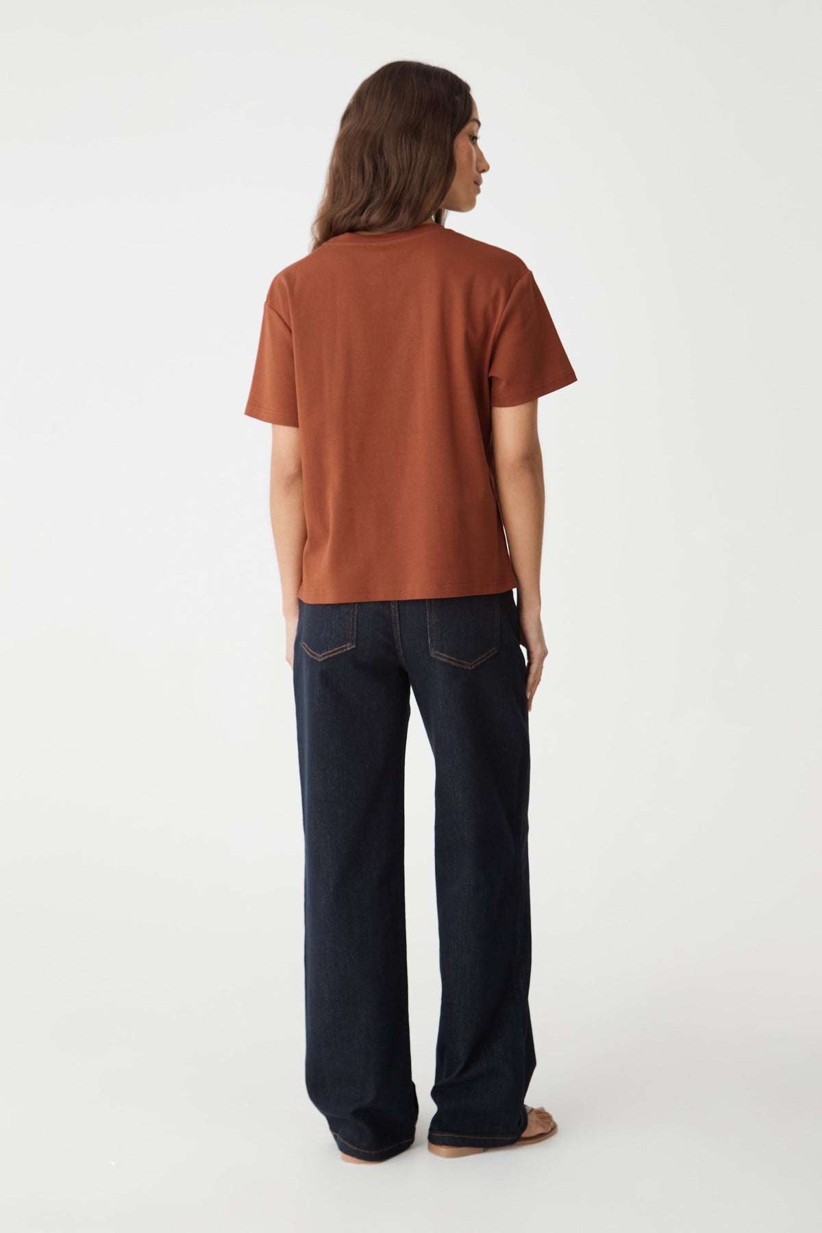 Back view of the terracotta May Relaxed Cotton T-shirt with navy jeans