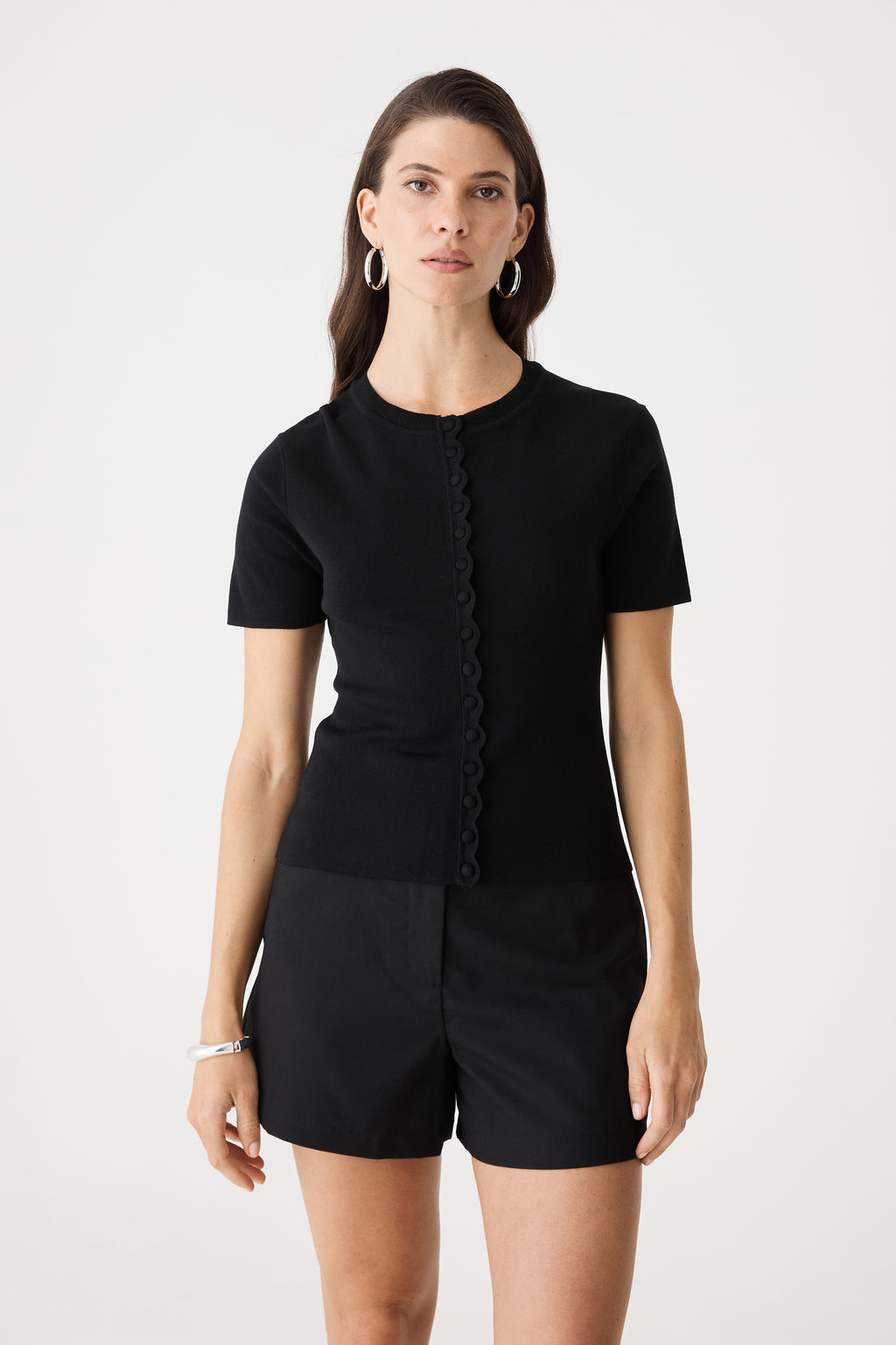 Mel Short Sleeve Scallop Knit in black, front view with scalloped button placket, worn with black shorts