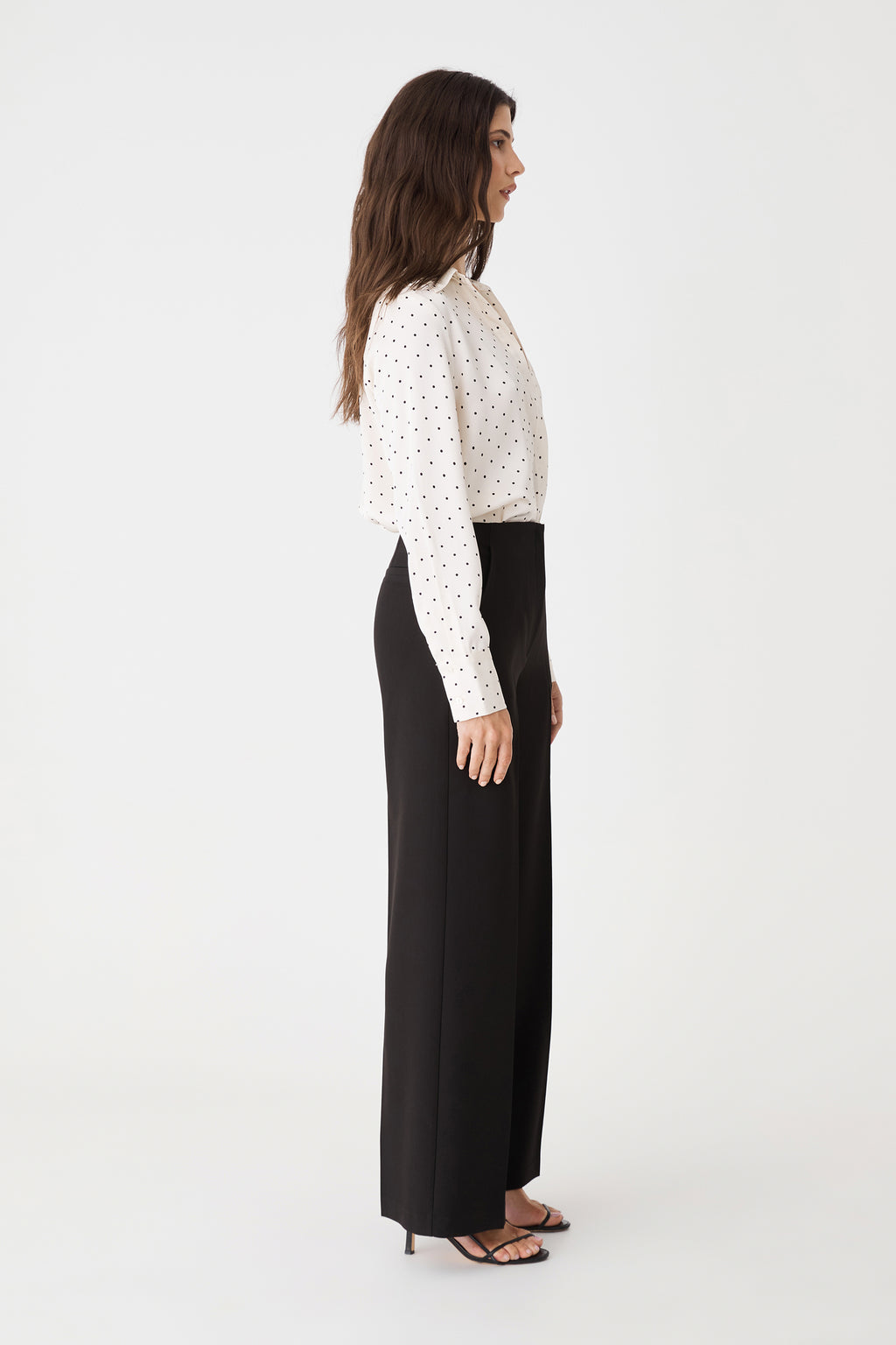 Side view showing the full-length straight leg and black heeled sandals
