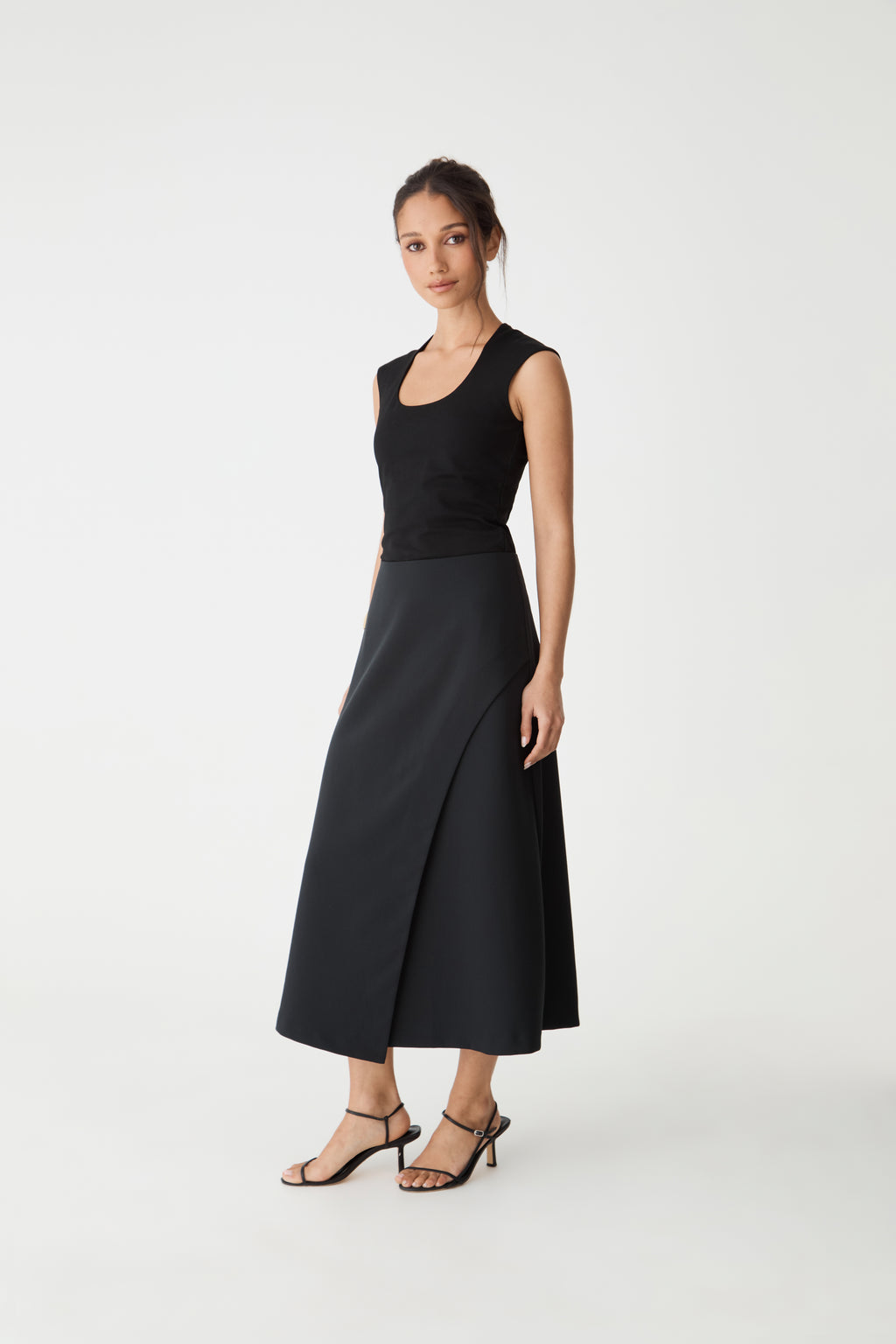 Side view of the black A-line midi skirt showing the flared hem