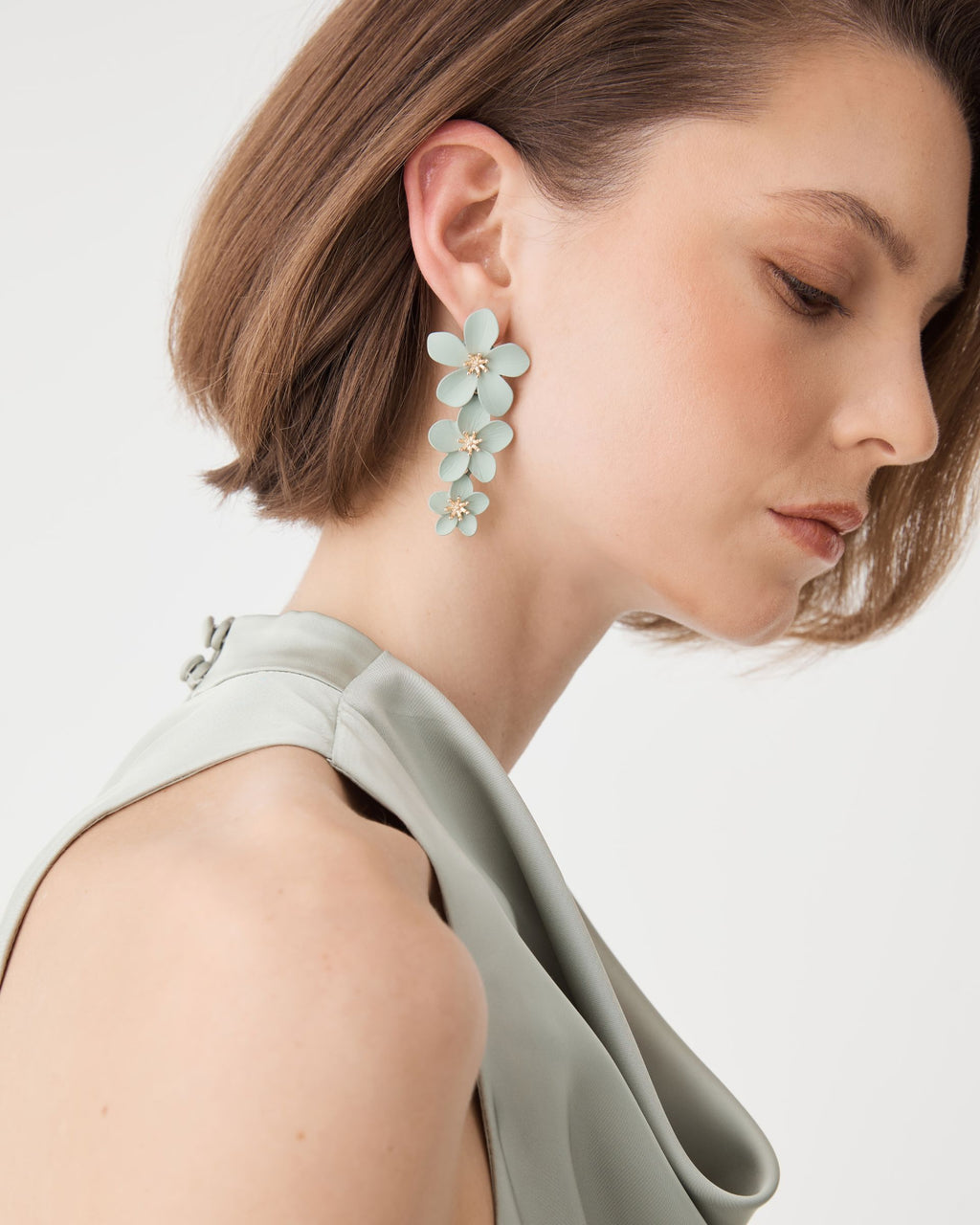 Close-up of the earring showing curved petals and gold-tone textured flower centres