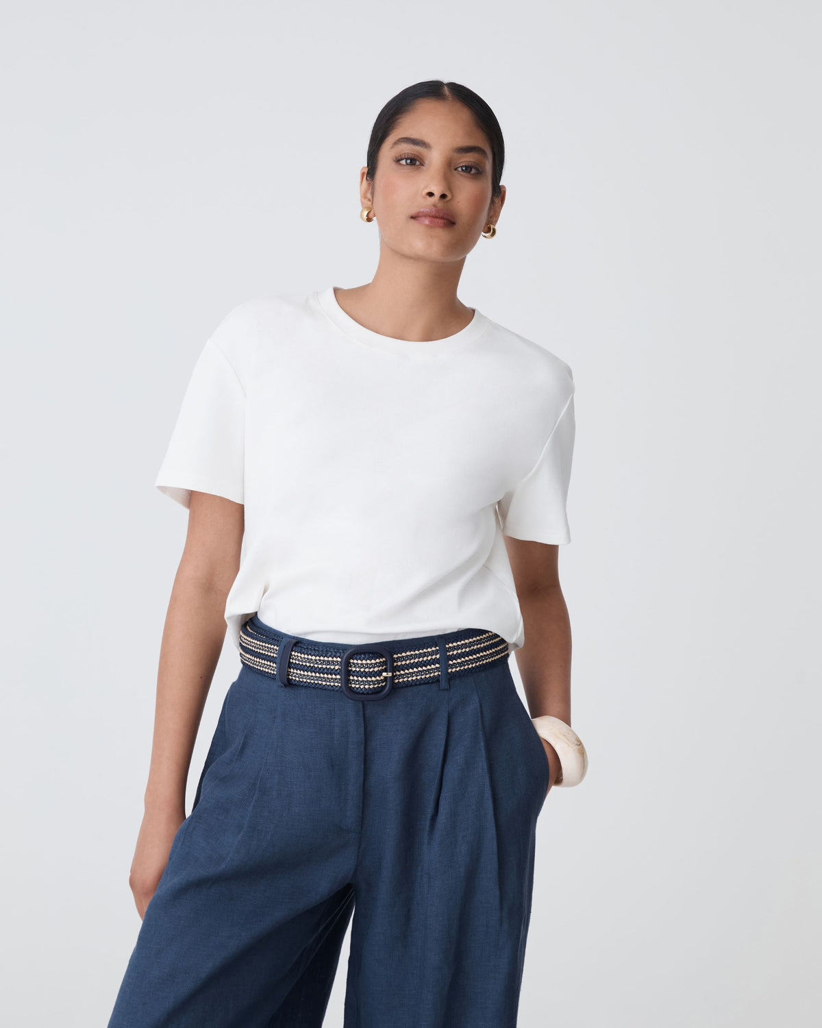 Maya Braid Belt in black two-tone braid, worn at the waist over navy trousers with a white tee
